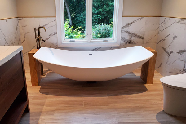 Top view of the Oasis Hammock Bath beneath a window with garden scenery in a New Jersey bathroom.