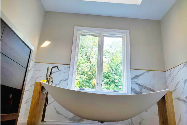 Side view of the Oasis Hammock Bath showing the floating hammock effect beneath a large window in a New Jersey home.