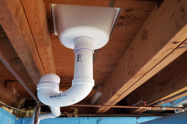 Underfloor plumbing showing a simple P-trap connection for the Oasis Hammock Bath installation in New Jersey.